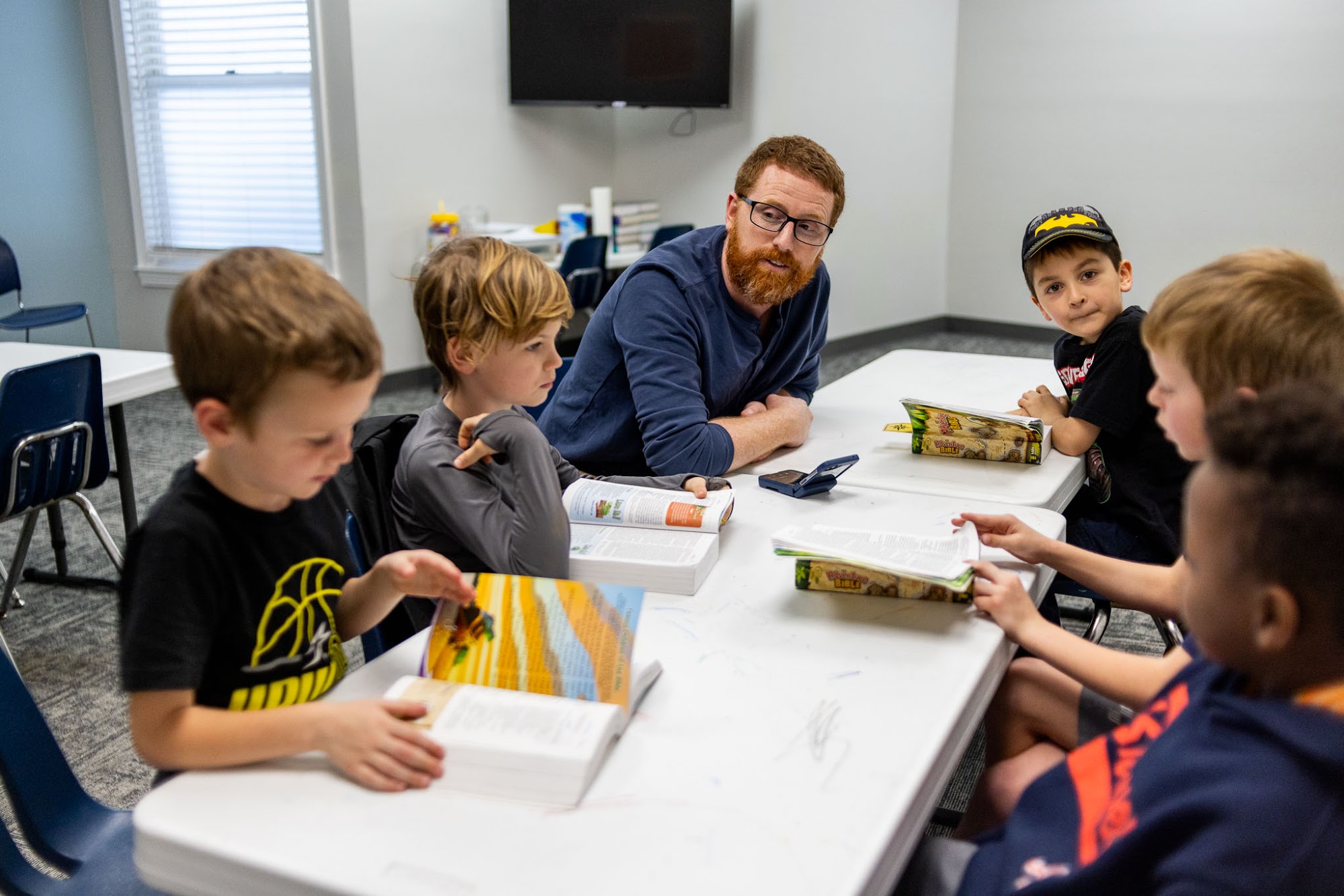 Kids working through a lesson at a table with their small group leader