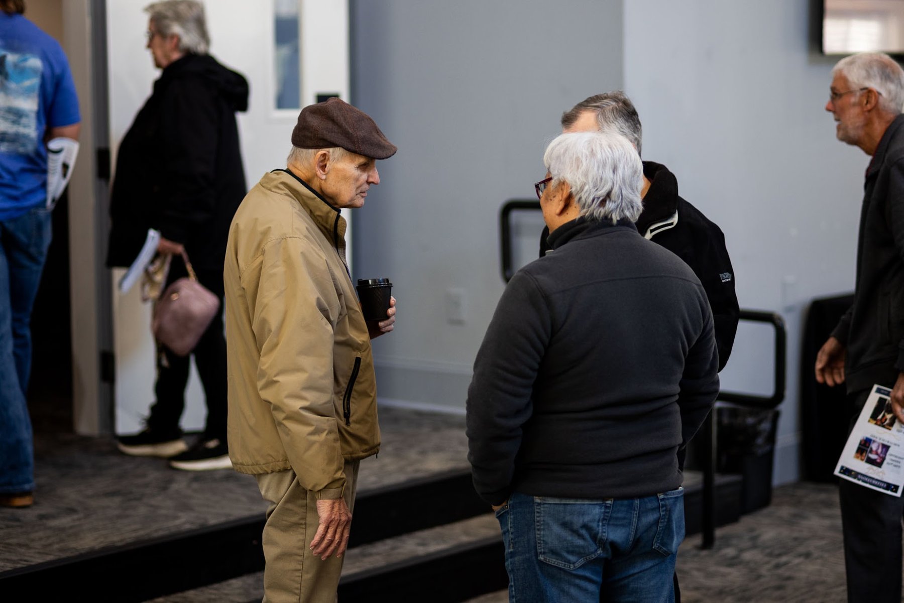 Members visiting over coffee in the foyer before service